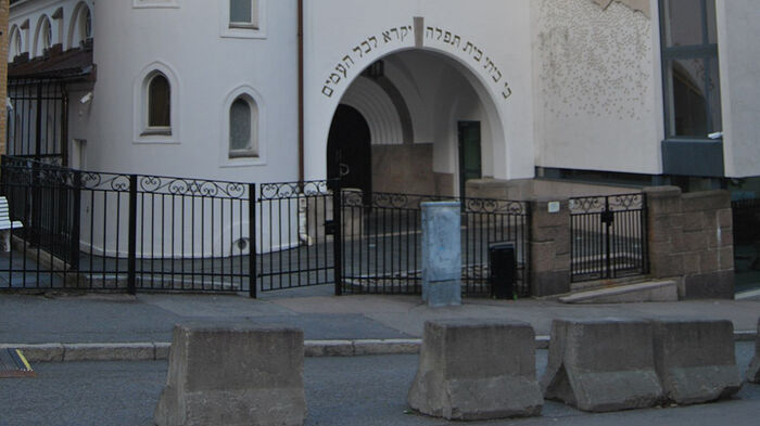 Inngangspartiet til synagogen i Oslo med betongsperringer foran.